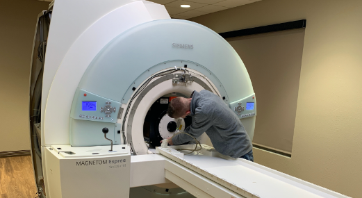 Man performing MRI repair service on imaging machine
